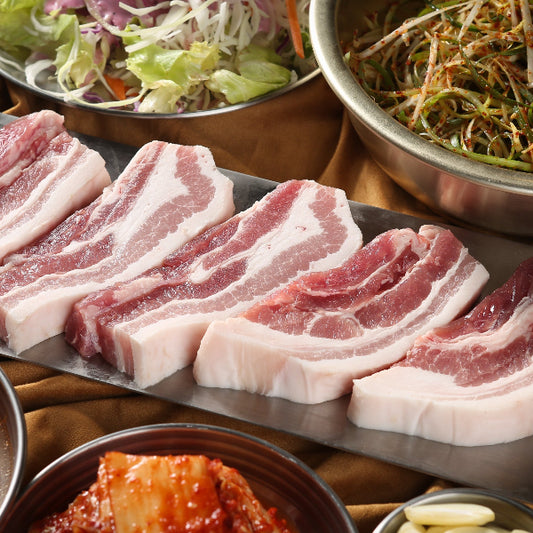 Plated raw meat with various side dishes on a wooden table